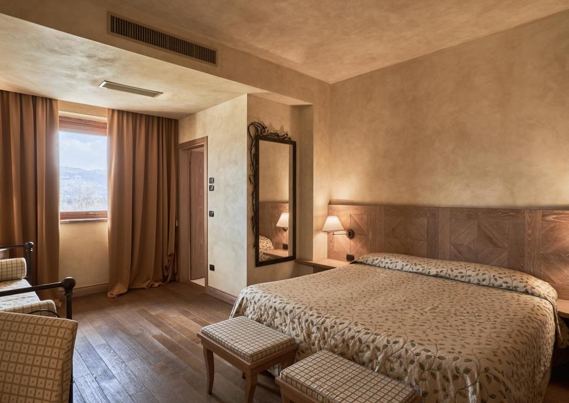 Camera accogliente con letto matrimoniale, arredamento classico e vista panoramica.