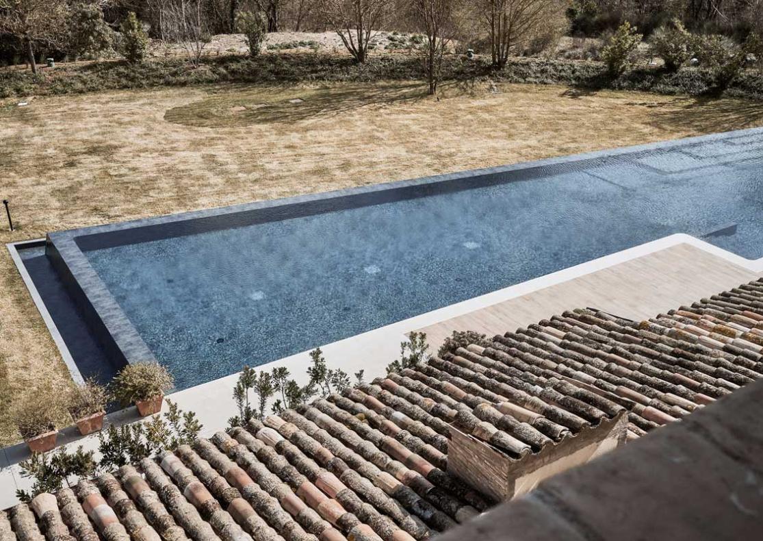 Piscina moderna in un giardino con tetto in tegole.