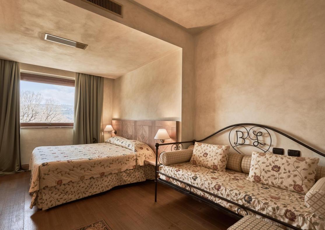 Camera accogliente con letto matrimoniale, divano e vista panoramica.