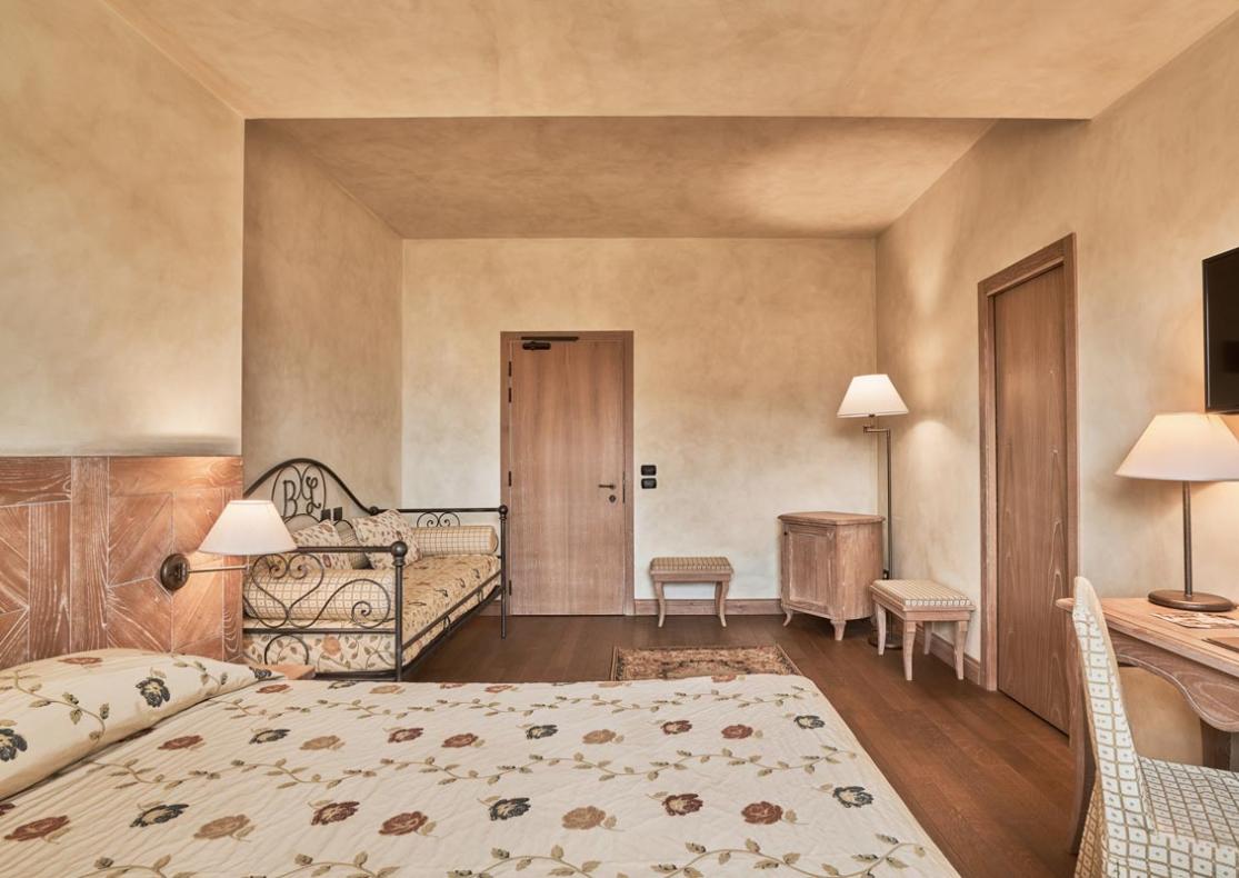 Camera accogliente con arredamento classico, letto matrimoniale e divano letto.