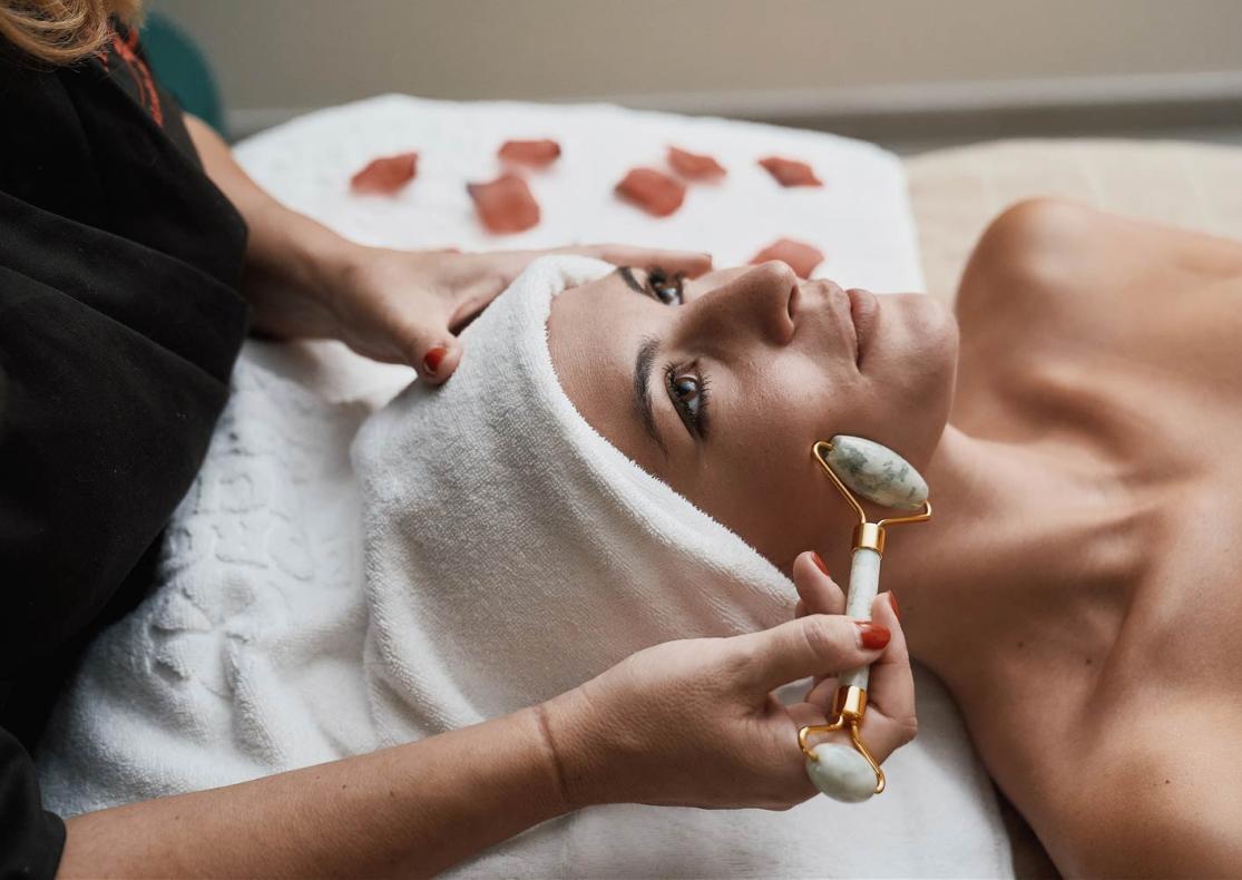 Trattamento viso con rullo di giada in un centro benessere.