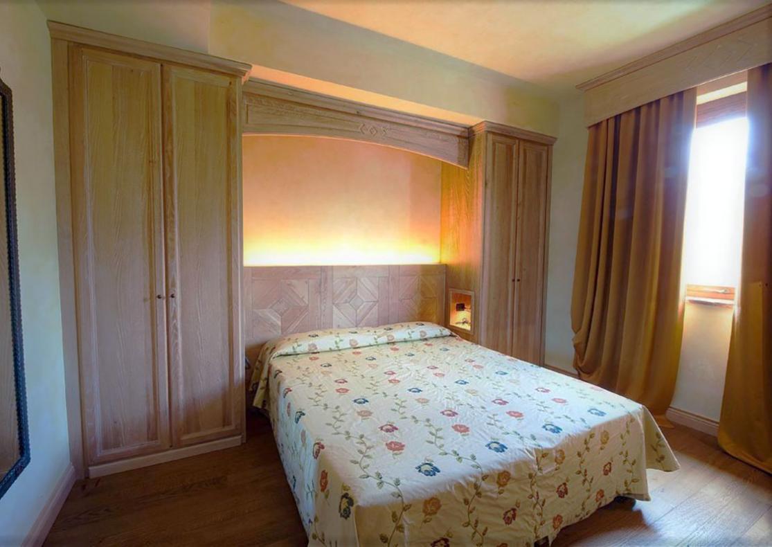 Camera da letto accogliente con armadi in legno e letto matrimoniale.