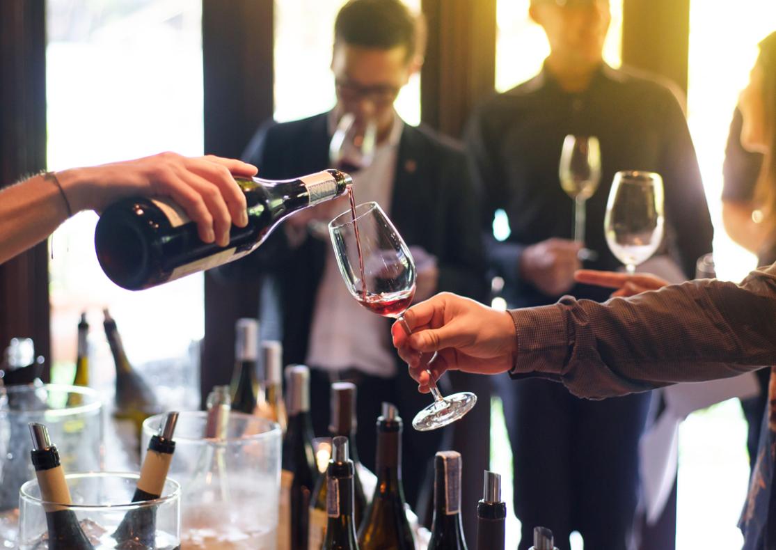 Wine tasting event with people sampling glasses.