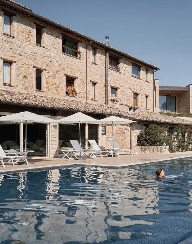 Piscina all'aperto con vista su un edificio in pietra.